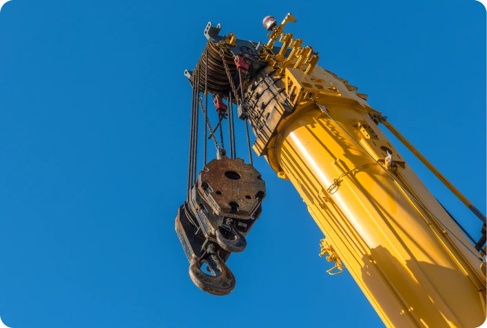 Crane lifting construction equipment skyward